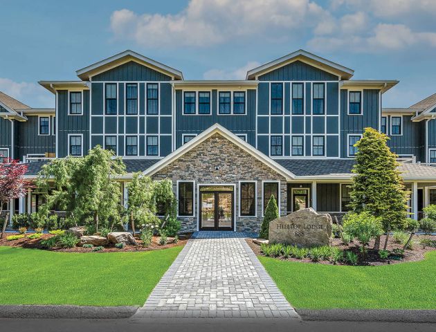 Exterior view of Hilltop Lodge Residences at The Preserve Sporting Club, surrounded by lush greenery and showcasing luxury architecture.