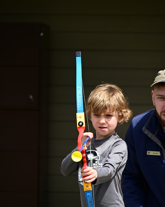 A young boy with a toy bow practices Nerf Archery, enjoying a playful activity at Preserve Resort & Spa.