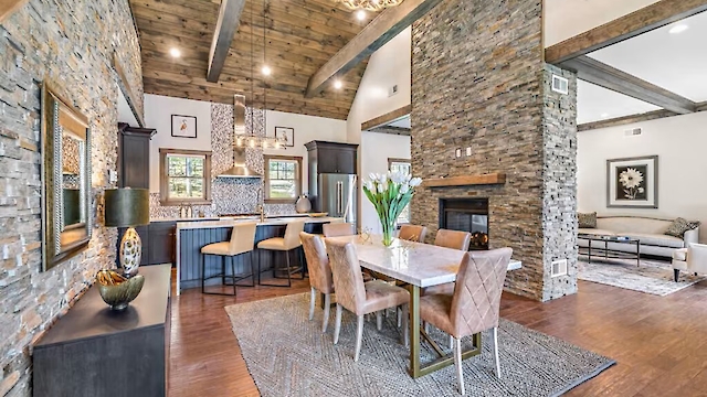 A modern open living space with dining area, kitchen, stone walls, wooden beams, chandelier, and stylish furniture decorates the room.